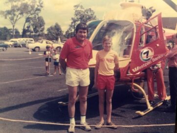 An old photo of Scott Collins and his father, who was also passionately involved in life-saving activities for over 40 years, posing in front of a helicopter.